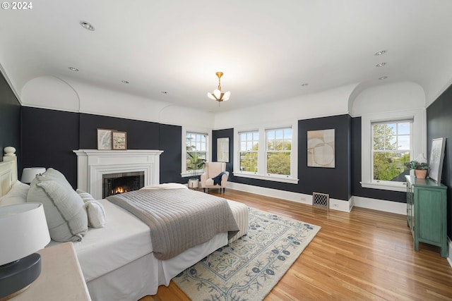 bedroom with light hardwood / wood-style floors and an inviting chandelier