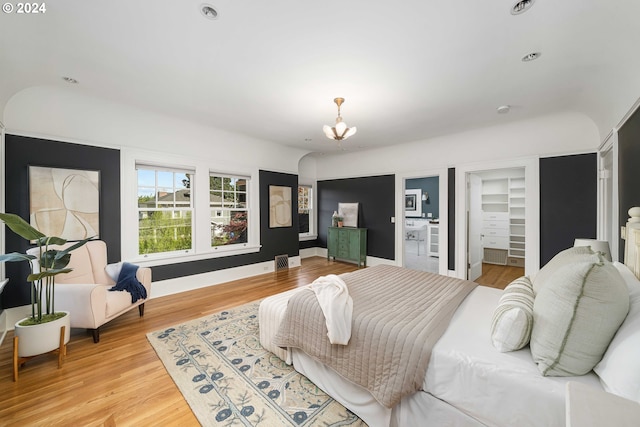 bedroom featuring light hardwood / wood-style flooring and a chandelier