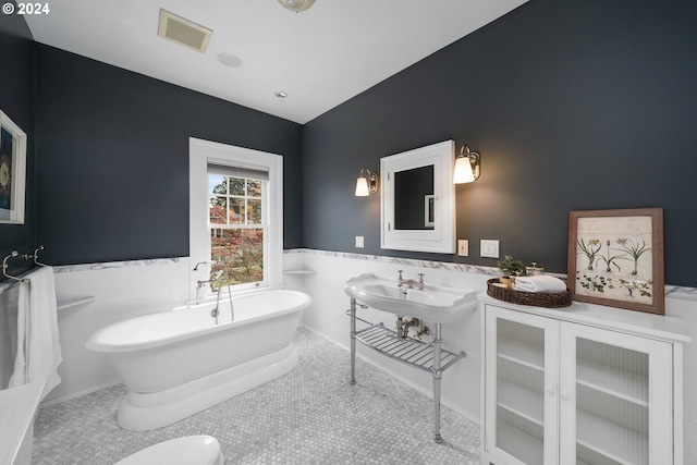 bathroom with tile flooring and a bath