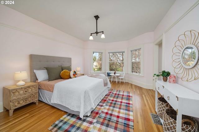 bedroom with an inviting chandelier and light wood-type flooring