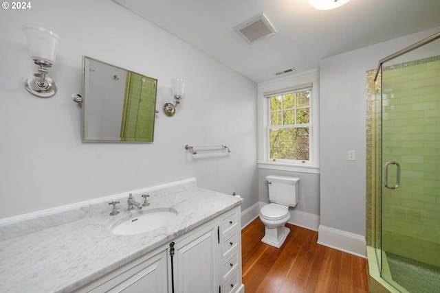 bathroom featuring a shower with door, wood-type flooring, toilet, and vanity