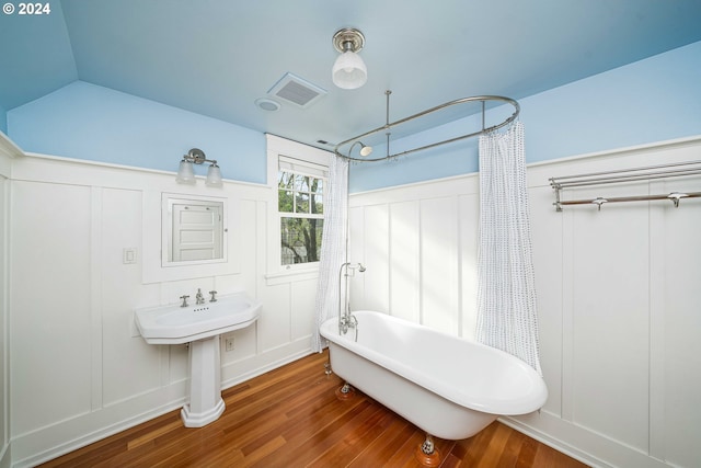 bathroom with wood-type flooring and shower / bath combo with shower curtain