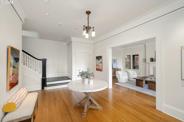 interior space with light hardwood / wood-style flooring, crown molding, and a chandelier