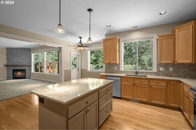 kitchen with a center island, stainless steel dishwasher, tasteful backsplash, light stone counters, and pendant lighting