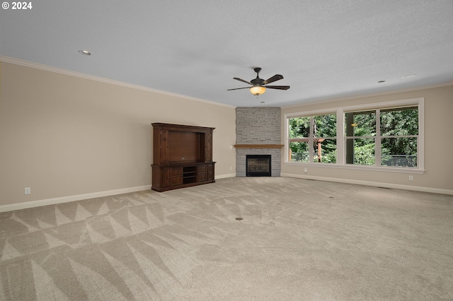 unfurnished living room featuring a textured ceiling, ceiling fan, a large fireplace, light carpet, and ornamental molding