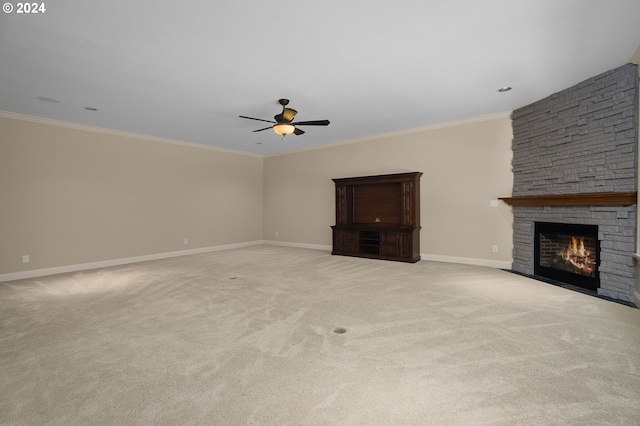 unfurnished living room featuring a fireplace, ornamental molding, light carpet, and ceiling fan