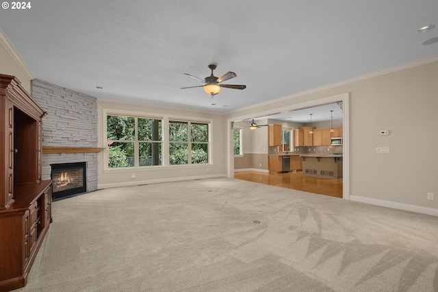 unfurnished living room with ornamental molding, light carpet, ceiling fan, and a fireplace