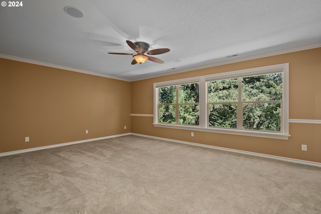 carpeted spare room featuring ceiling fan, ornamental molding, and a textured ceiling