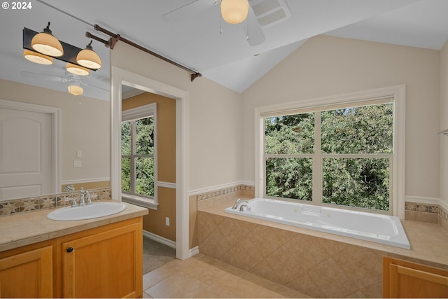 bathroom with a healthy amount of sunlight, vaulted ceiling, ceiling fan, and tile patterned flooring