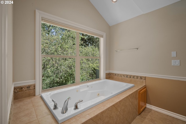 bathroom featuring lofted ceiling, tile patterned flooring, and a relaxing tiled tub