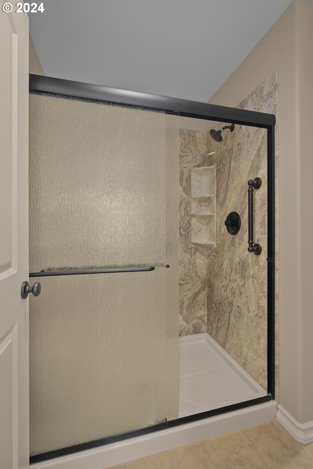 bathroom featuring a shower with shower door and tile patterned floors