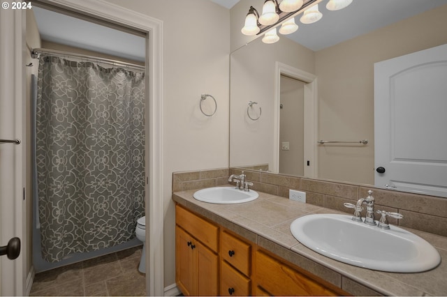 full bath with toilet, double vanity, a sink, and a shower with shower curtain