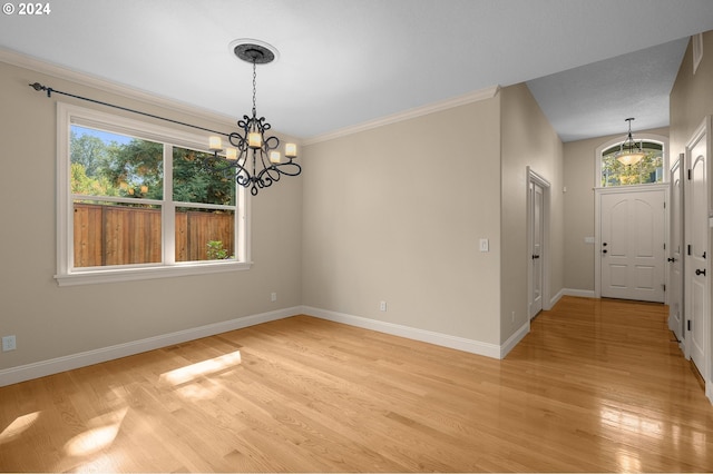 foyer with ornamental molding, a chandelier, and light hardwood / wood-style floors