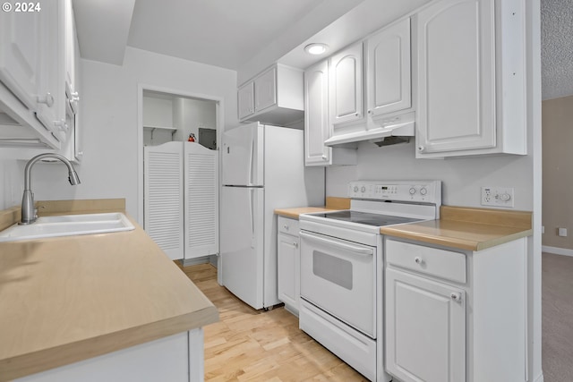 kitchen with white appliances, white cabinetry, sink, and light wood-type flooring