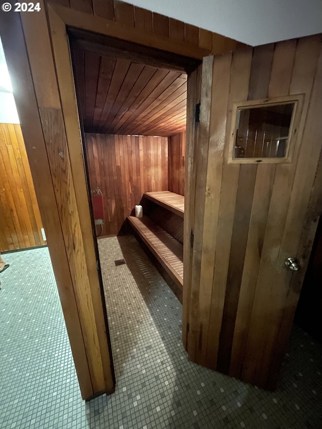 view of sauna / steam room featuring tile patterned flooring, wooden walls, and wooden ceiling