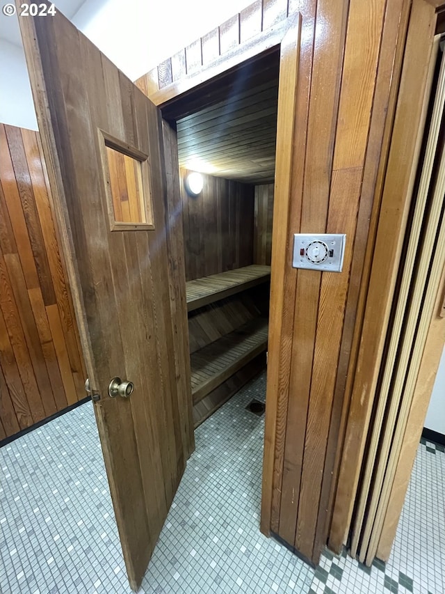 view of sauna featuring wood walls and tile patterned floors