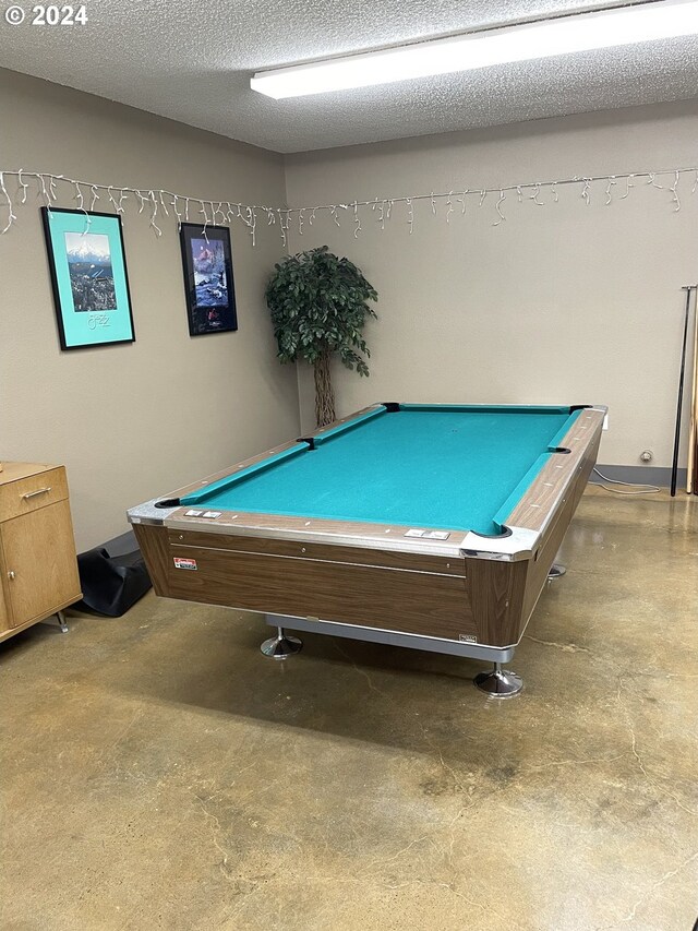 recreation room featuring concrete flooring, billiards, and a textured ceiling