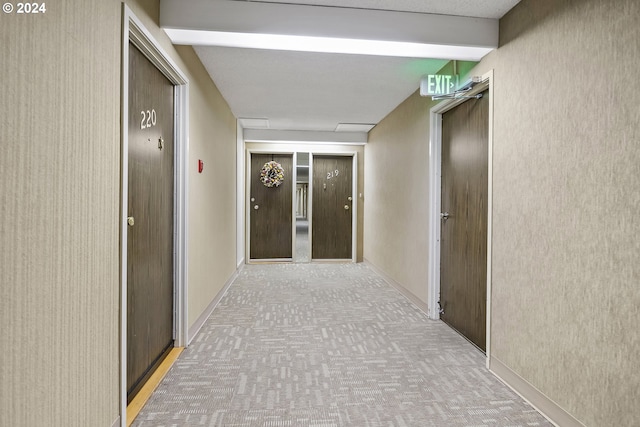 corridor featuring beamed ceiling and carpet