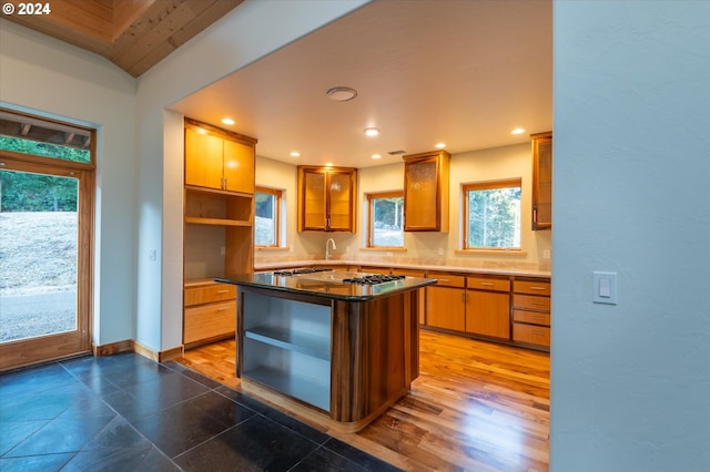 kitchen featuring a kitchen island, stainless steel gas cooktop, dark hardwood / wood-style floors, and sink