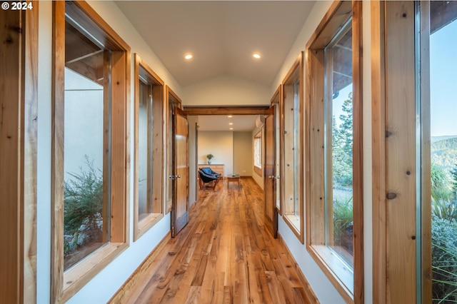 hall featuring light hardwood / wood-style floors and vaulted ceiling