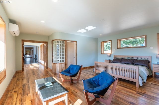 bedroom featuring a wall mounted air conditioner and hardwood / wood-style flooring