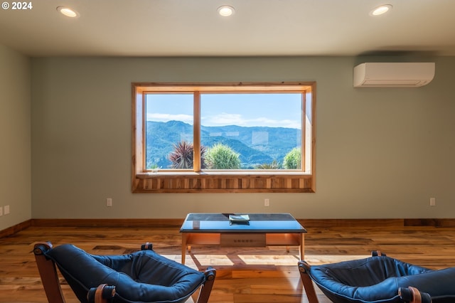 living area featuring hardwood / wood-style floors, an AC wall unit, and a mountain view