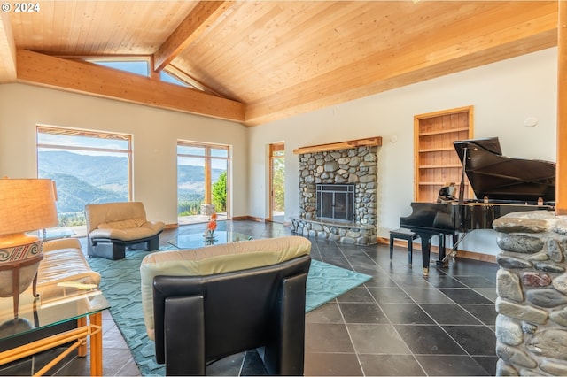 living room featuring beamed ceiling, a stone fireplace, a mountain view, dark tile flooring, and wood ceiling