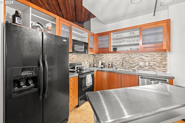 kitchen featuring sink, backsplash, black appliances, and stainless steel counters