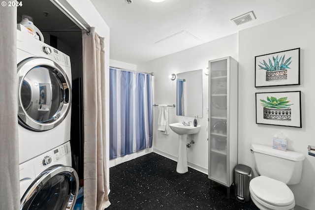 clothes washing area featuring stacked washer and dryer