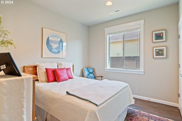 bedroom with baseboards, wood finished floors, and recessed lighting