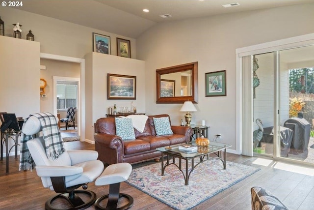 living room with wood finished floors, baseboards, high vaulted ceiling, and recessed lighting