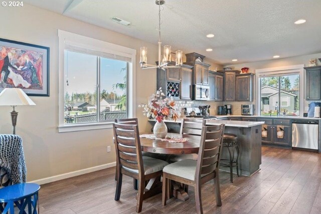 dining room featuring a chandelier, hardwood / wood-style floors, recessed lighting, and baseboards