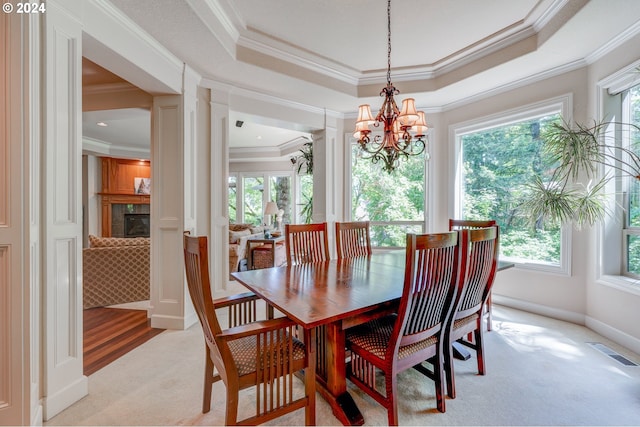 dining space featuring a healthy amount of sunlight, a tray ceiling, and light colored carpet