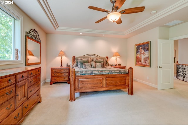 carpeted bedroom with ceiling fan, crown molding, and a tray ceiling