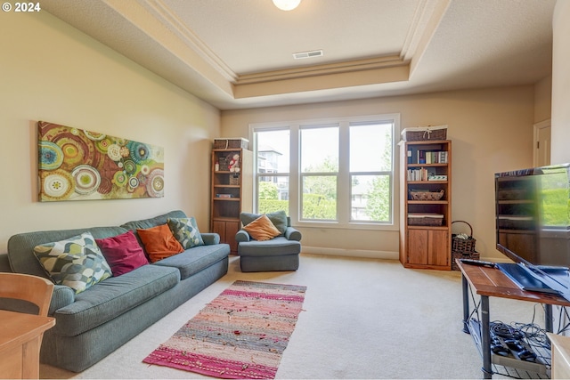 carpeted living room with a raised ceiling and ornamental molding