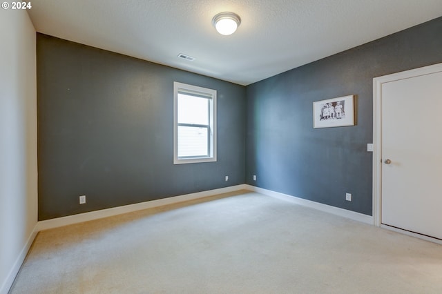 carpeted empty room featuring a textured ceiling