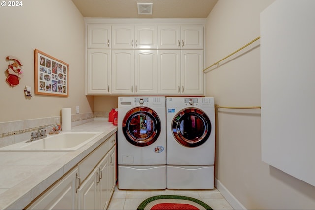 laundry area with light tile patterned flooring, cabinets, independent washer and dryer, and sink