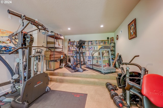 workout room featuring carpet flooring and a textured ceiling