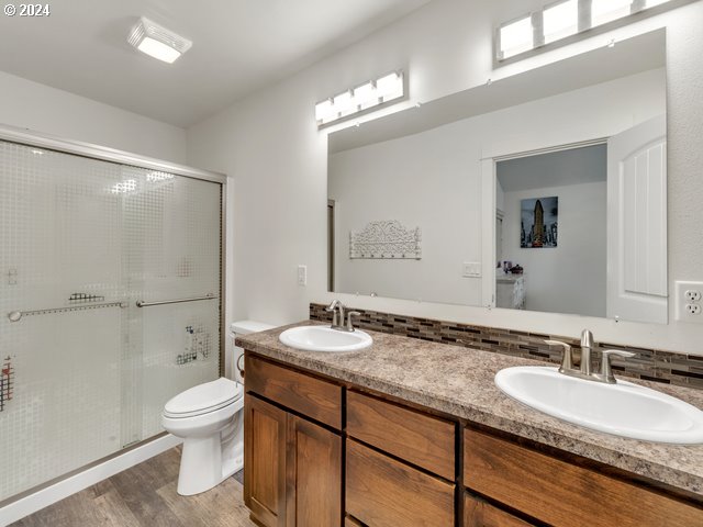 566 N 11th St, Aumsville, OR 97325 - full bathroom featuring double vanity, a shower stall, toilet, and wood finished floors