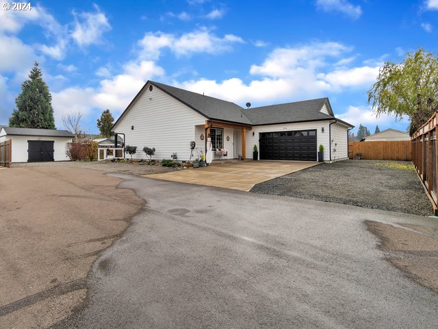 566 N 11th St, Aumsville, OR 97325 - view of front of house with an attached garage and asphalt driveway
