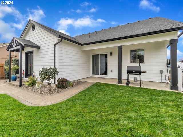 566 N 11th St, Aumsville, OR 97325 - rear view of house featuring a patio, a yard, and a shingled roof