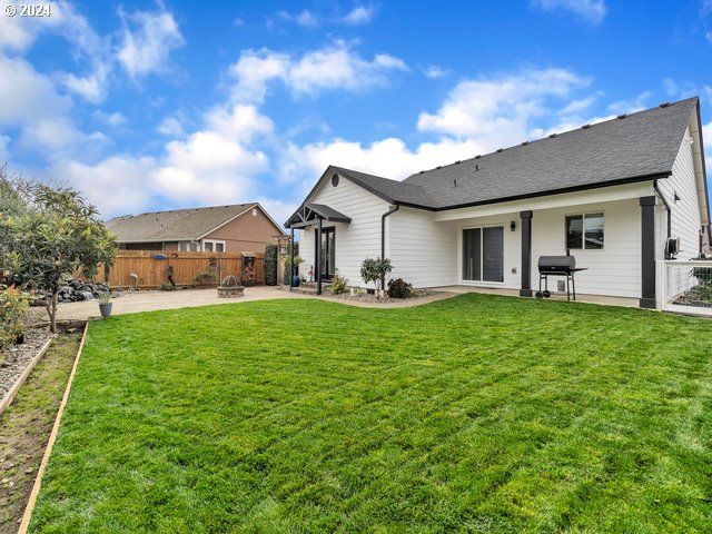 566 N 11th St, Aumsville, OR 97325 - rear view of property featuring a patio area, a fire pit, and roof with shingles