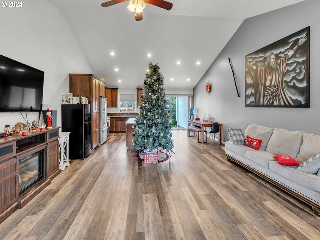 566 N 11th St, Aumsville, OR 97325 - living room with vaulted ceiling, ceiling fan, light wood-style flooring, recessed lighting, and a glass covered fireplace
