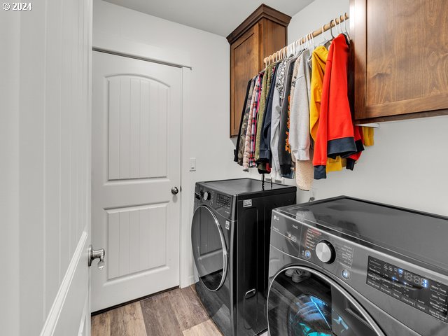 566 N 11th St, Aumsville, OR 97325 - washroom featuring washer and dryer, wood finished floors, and cabinet space