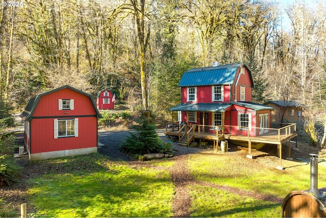 back of property featuring an outdoor structure and a lawn