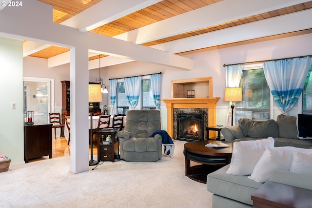 carpeted living room featuring beamed ceiling, a high end fireplace, and wooden ceiling