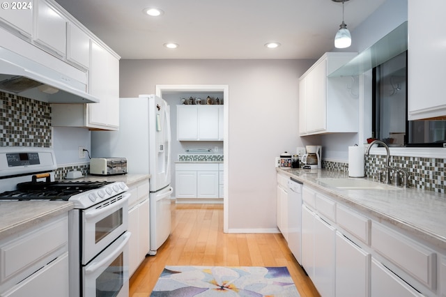 kitchen with white cabinetry, hanging light fixtures, sink, light hardwood / wood-style floors, and white appliances