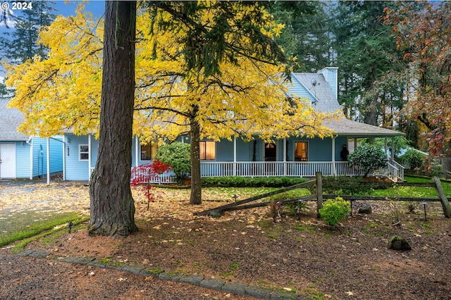 view of property hidden behind natural elements featuring a porch