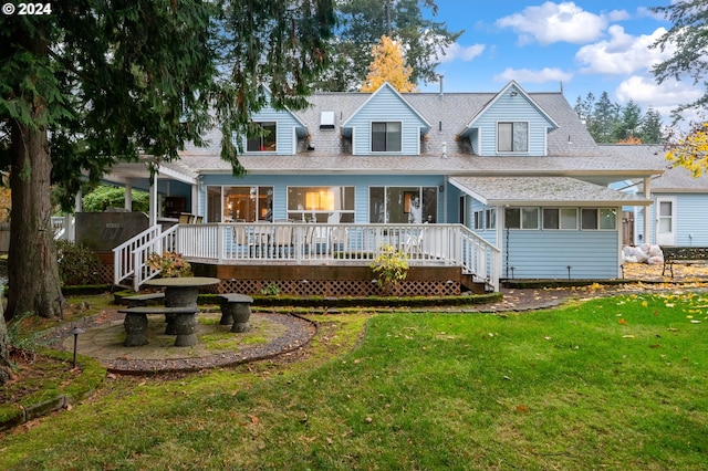 rear view of house with a sunroom, a lawn, and a wooden deck