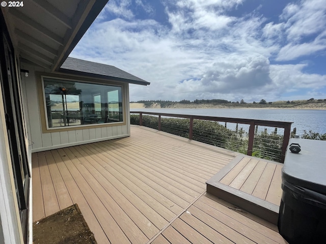 wooden terrace featuring area for grilling and a water view